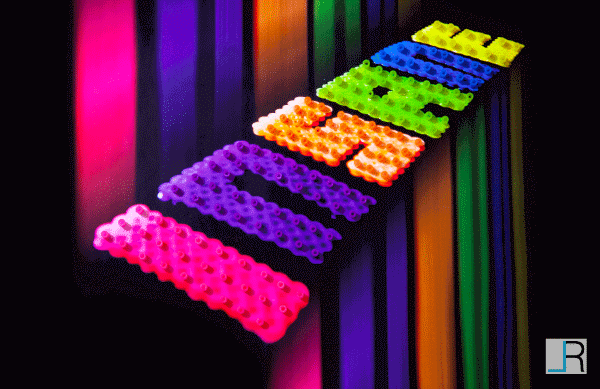 The word Insane made out of rainbow beads on a black background